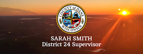 Image of Dane County from air with the County of Dane logo placed over the image. It also reads Sarah Smith Dane County Board Supervisor, District 24.